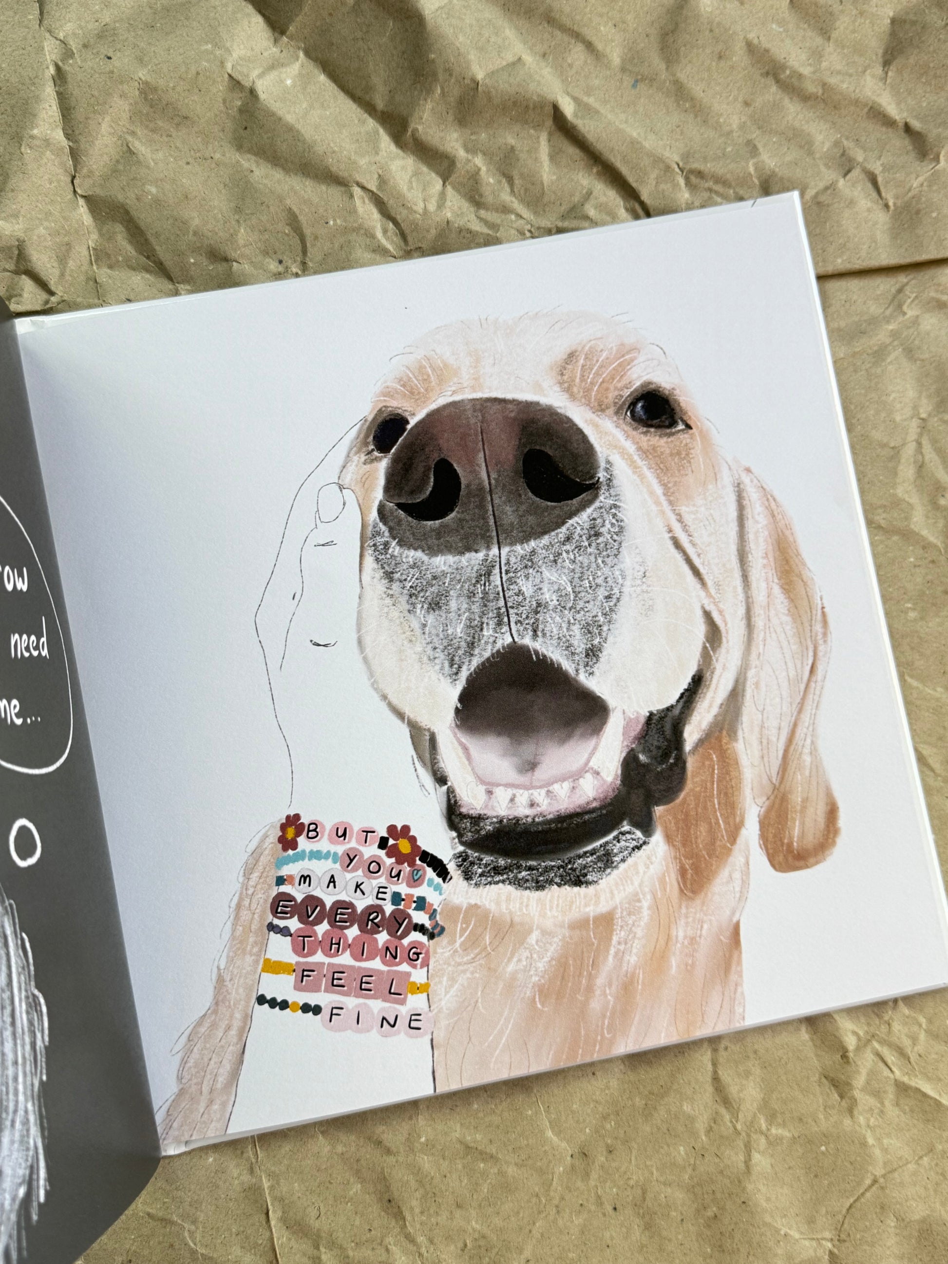 A book featuring a painted dog portrait, shown open on crumpled brown paper. 